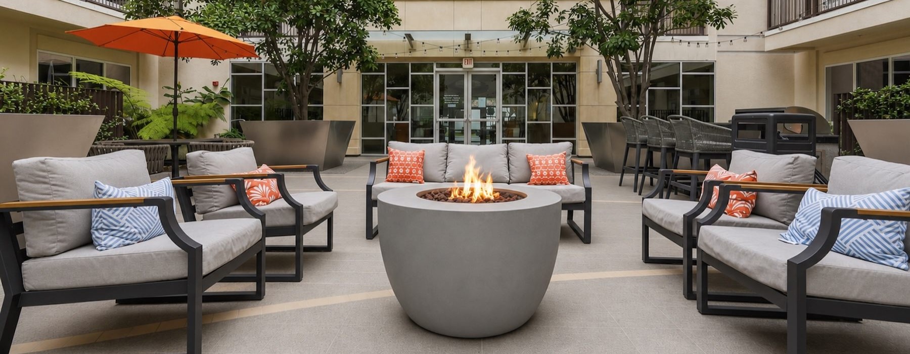 a courtyard with a couch, fire pit and chairs